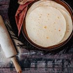 Mexikanische Weizentortillas mit Teigroller und Mehl