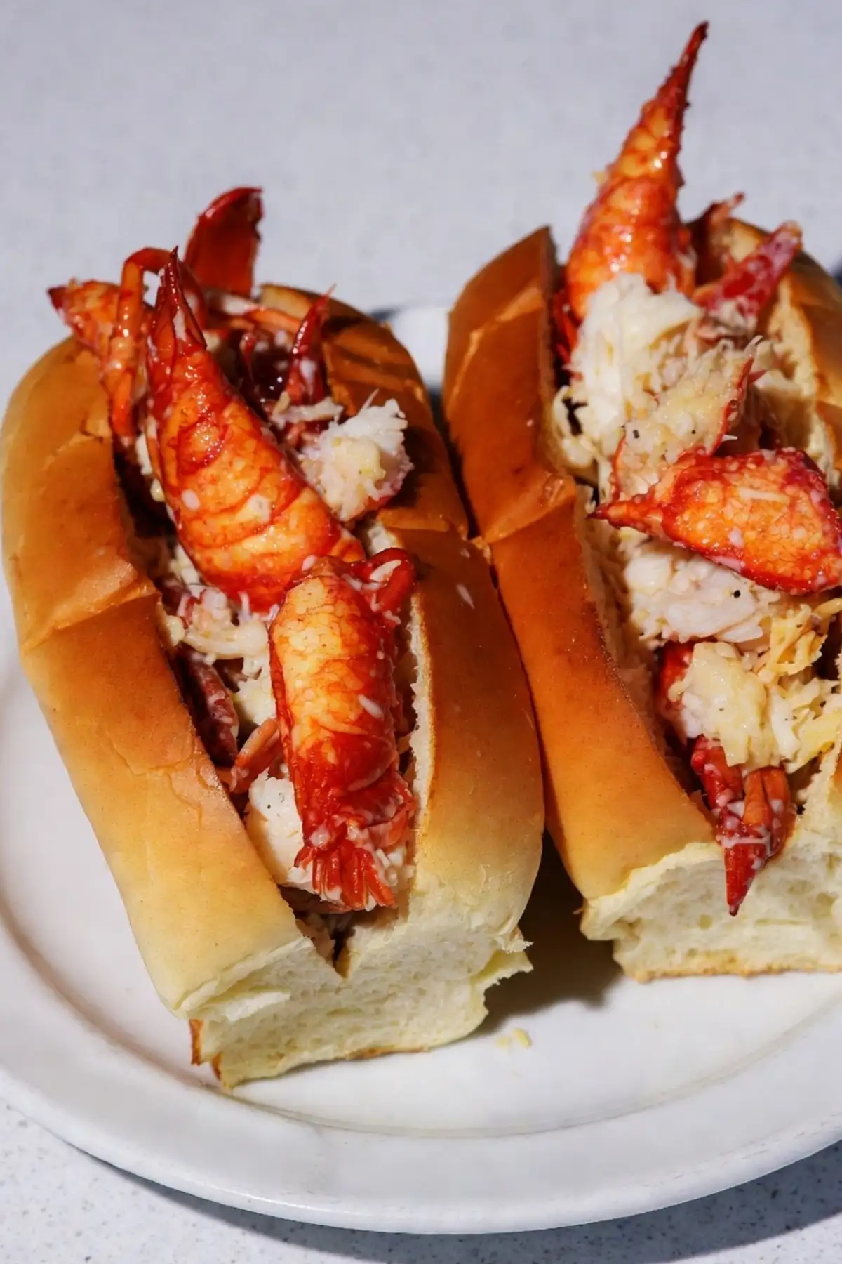 Frisch selbstgemachte original amerikanische Lobster Rolls Connecticut-Style: saftiges Hummerfleisch serviert im getoasteten New-England-Bun mit warmer Butter.