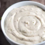 Frisch selbstgemachtes original amerikanisches Ranch Dressing in einem Glas, cremig-weiß mit Kräutern – das echte Hidden Valley Feeling zu Hause.