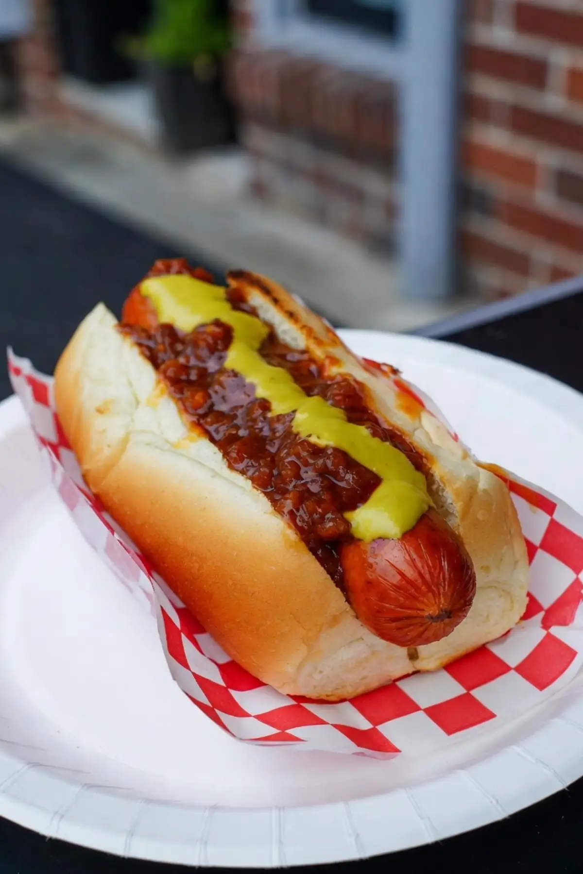 Frisch selbstgemachte original amerikanische Coney Island Hot Dogs aus Detroit-Style: saftiges Rindswürstchen im weichen Bun, überladen mit würziger Chili-Sauce ohne Bohnen, gelbem Senf und feinen Zwiebelwürfeln.